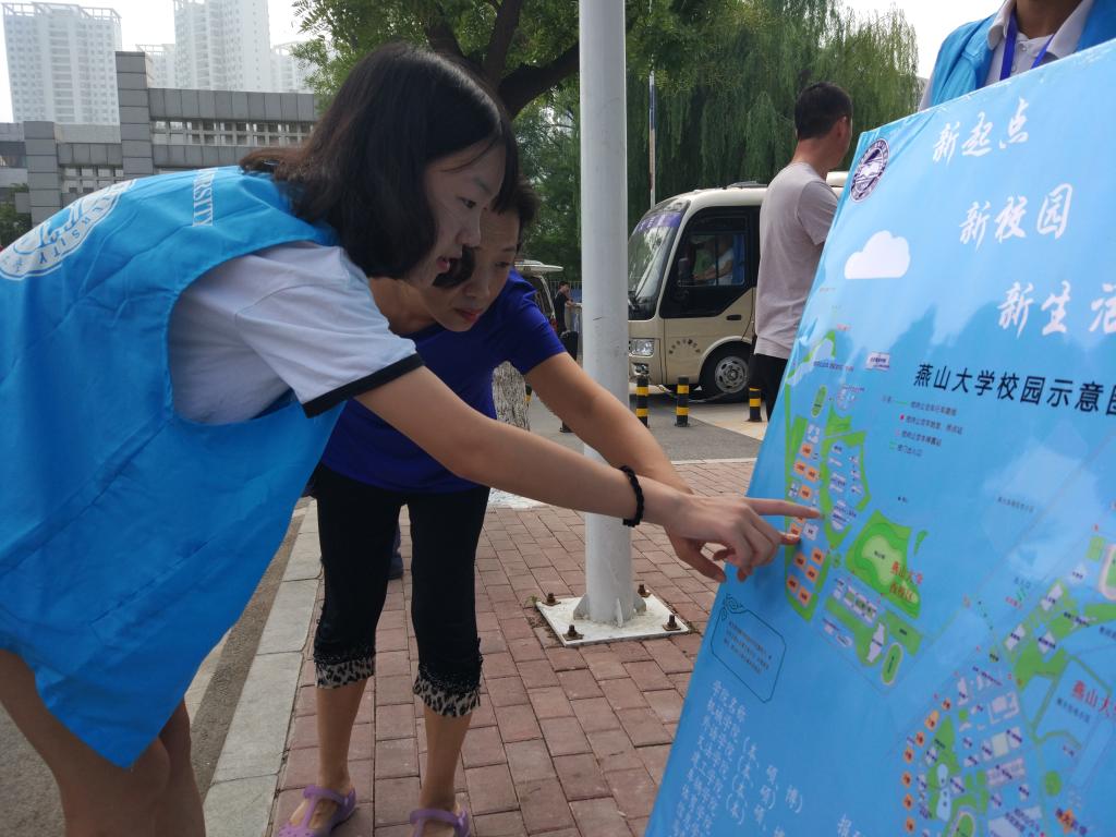 (志愿者为新生家长指路)